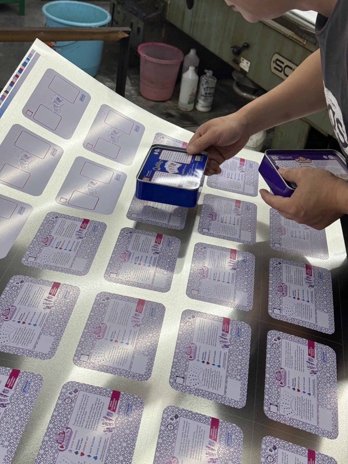 Junmei team member comparing finished tin samples with printed tinplate sheets
